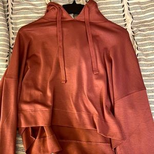 Pink silk hoodie that is a little cropped.